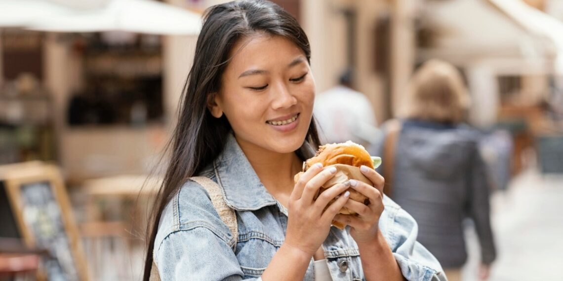 asian woman being happy after buying street food cropped 1756217996502.jpg