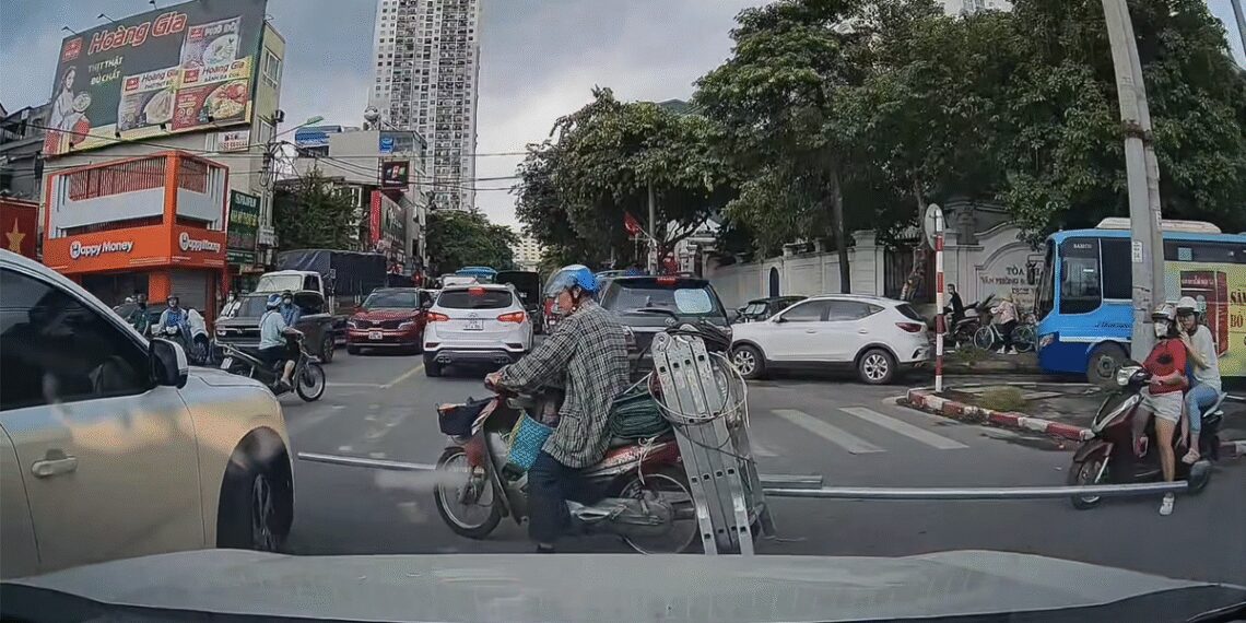 Người đàn ông chở thanh kim loại đi như Tôn Ngộ Không vác gậy qua giao lộ cong kenh 1756550573523.jpg